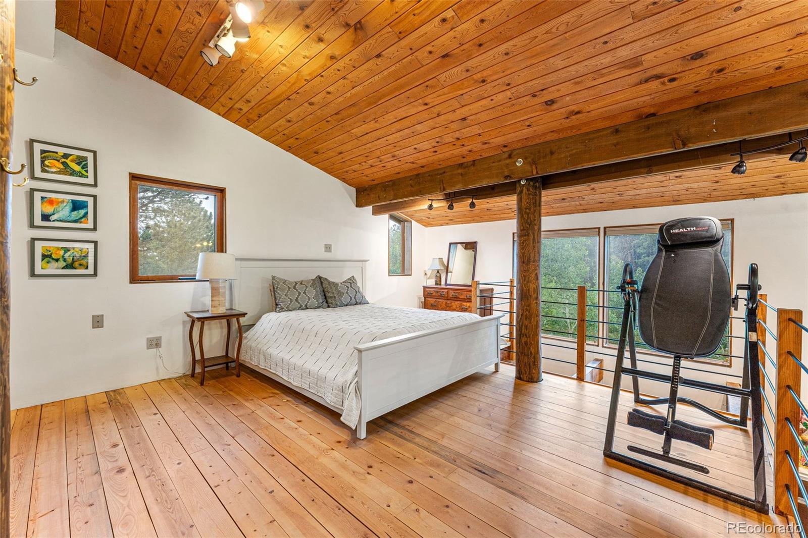 198 Range Road Nederland, CO 80466 - Photo 22 of 40 a spacious bedroom with a bed and wooden floor