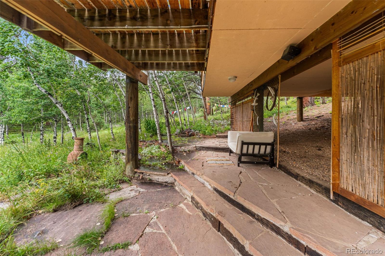 198 Range Road Nederland, CO 80466 - Photo 36 of 40 a sitting area with lots of trees in front of it