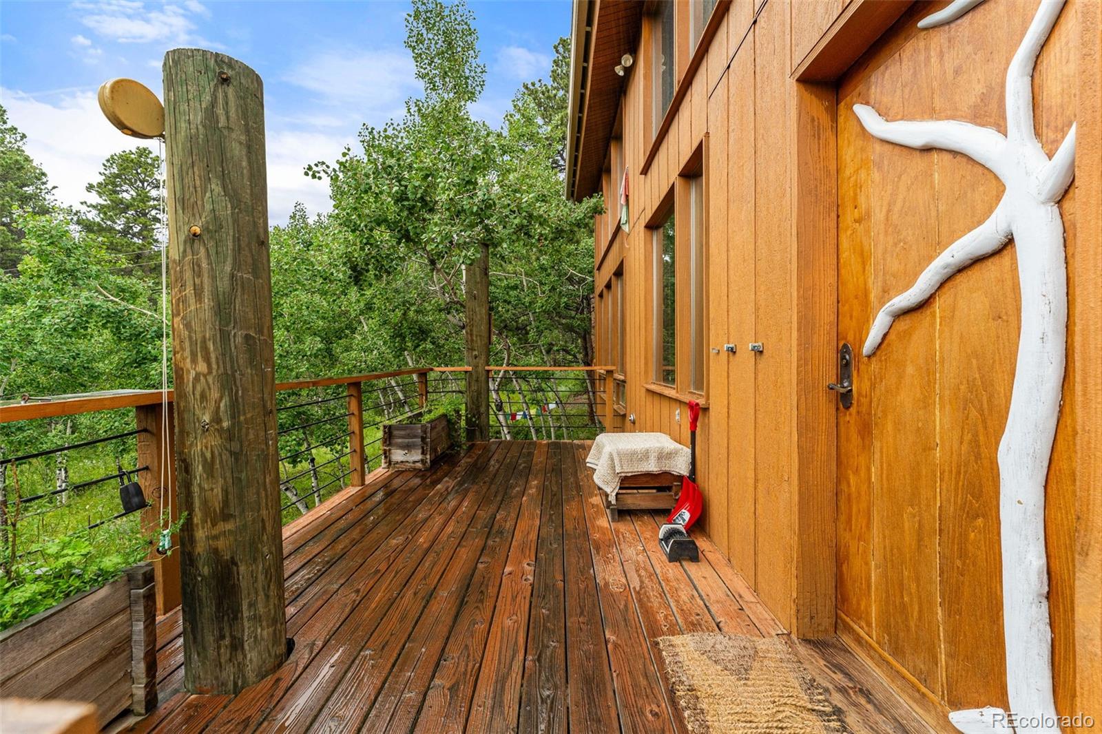198 Range Road Nederland, CO 80466 - Photo 4 of 40 a balcony with wooden floor and outdoor seating
