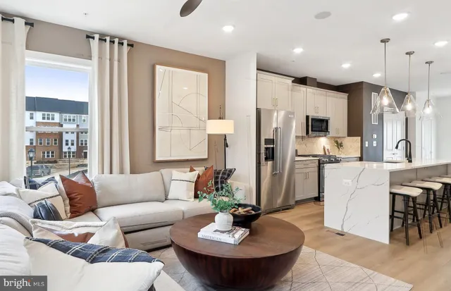 a living room with kitchen island furniture and a view of kitchen