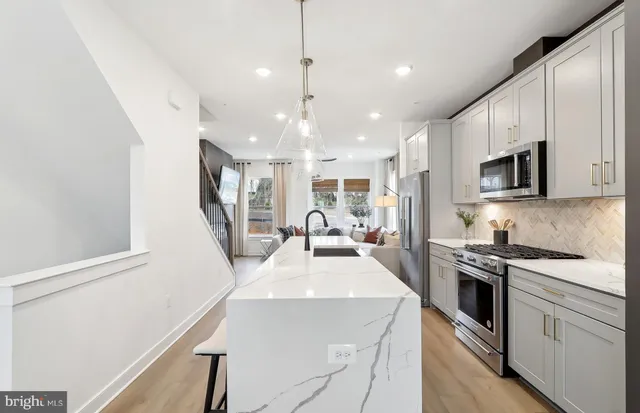 a kitchen with kitchen island a stove a sink a microwave and refrigerator