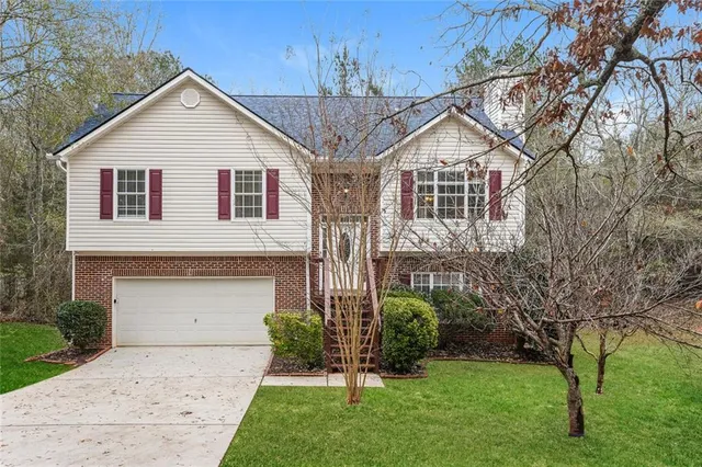 a front view of a house with a garden and plants