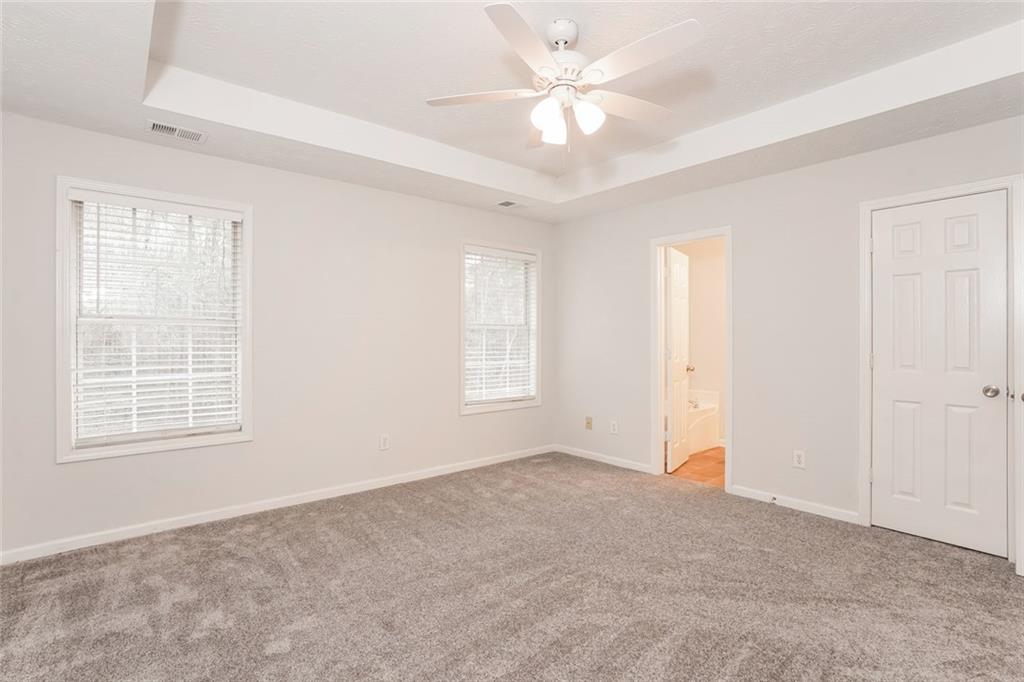 1024 Miss Amber Way Locust Grove, GA 30248 - Photo 14 of 25 an empty room with chandelier fan and windows