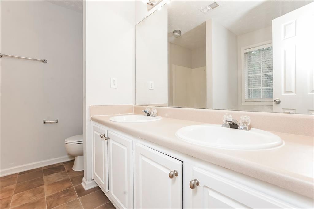 1024 Miss Amber Way Locust Grove, GA 30248 - Photo 15 of 25 a bathroom with a double vanity sink toilet and a mirror