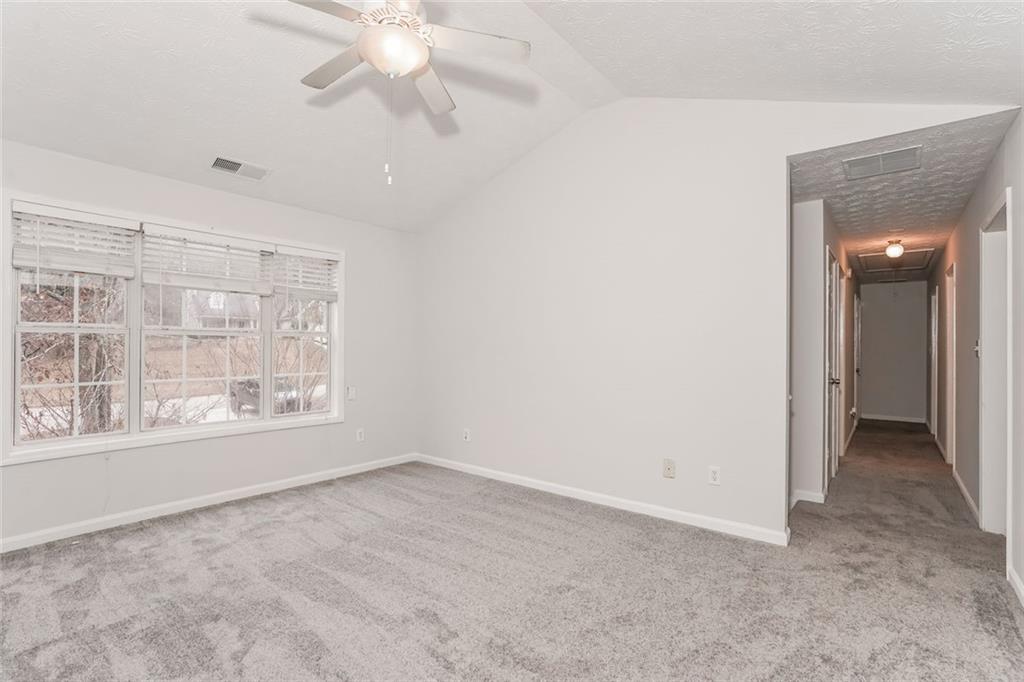 1024 Miss Amber Way Locust Grove, GA 30248 - Photo 20 of 25 an empty room with chandelier fan and windows