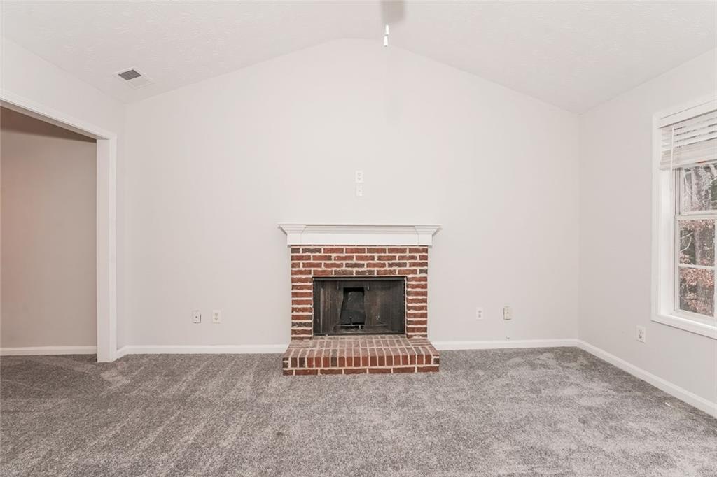 1024 Miss Amber Way Locust Grove, GA 30248 - Photo 5 of 25 an empty room with a fireplace