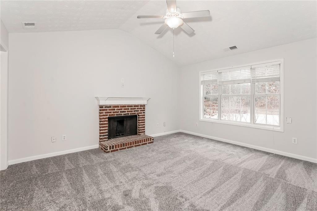 1024 Miss Amber Way Locust Grove, GA 30248 - Photo 6 of 25 an empty room with windows and fireplace