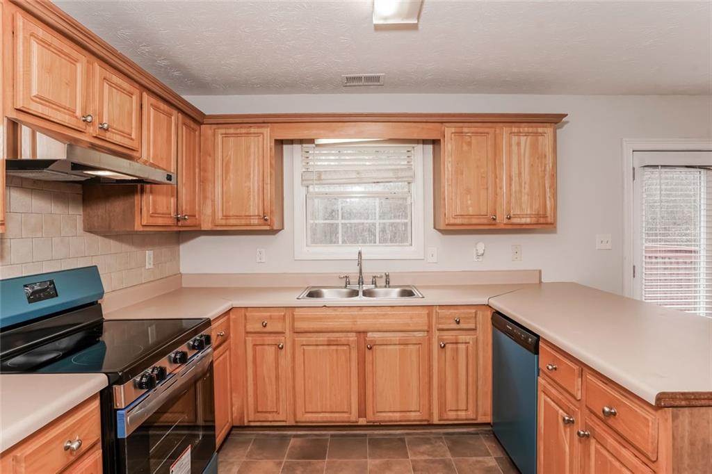 1024 Miss Amber Way Locust Grove, GA 30248 - Photo 9 of 25 a kitchen with stainless steel appliances a sink stove and cabinets