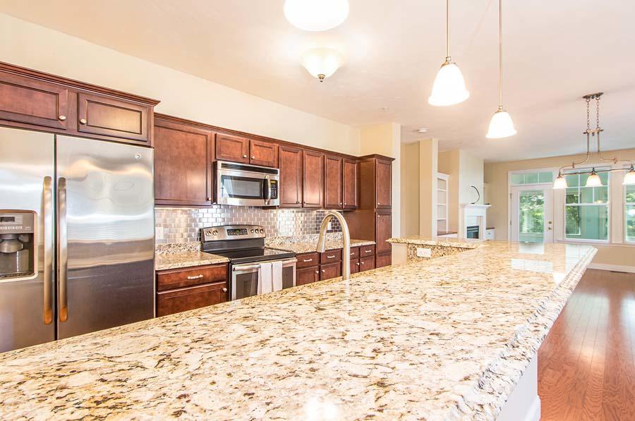 22 Southport Drive Mashpee, MA 02649 - Photo 7 of 27 a kitchen with stainless steel appliances kitchen island granite countertop a refrigerator and a sink