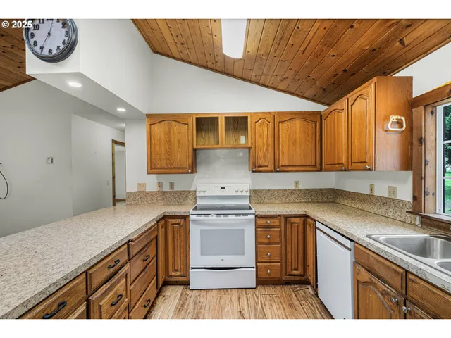 a kitchen with kitchen island granite countertop a sink stove and cabinets
