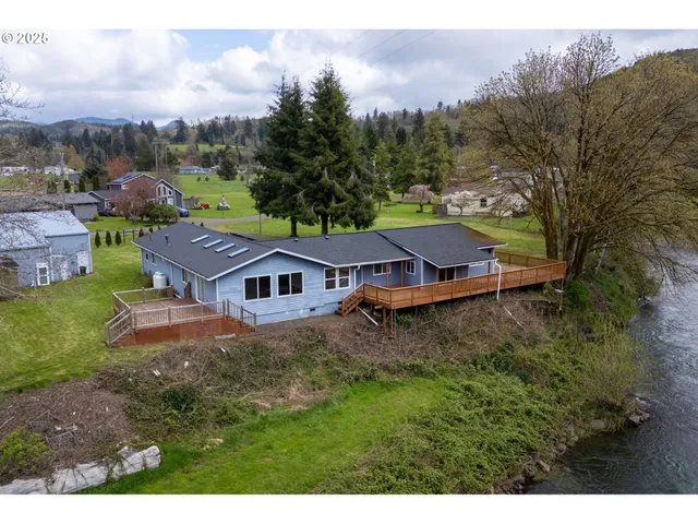 a view of a big house with a big yard and large trees