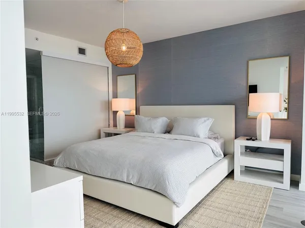 a large bed sitting in a bedroom next to a window