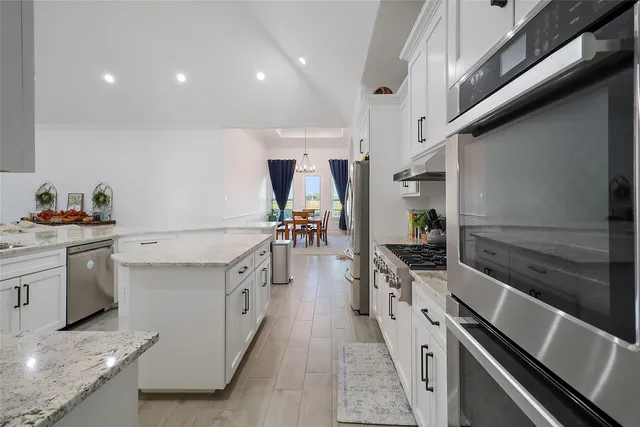 a kitchen with stainless steel appliances a sink stove and refrigerator