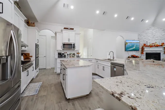 a kitchen with stainless steel appliances granite countertop a sink stove refrigerator and a sink