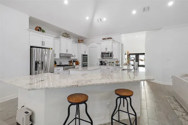 a kitchen with stainless steel appliances granite countertop a sink and a refrigerator