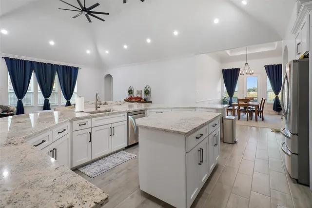 a kitchen that has a lot of cabinets in it and wooden floors