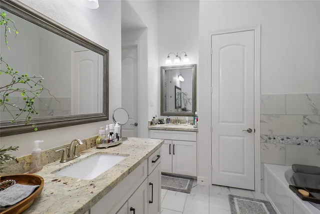 a bathroom with a granite countertop sink and a mirror
