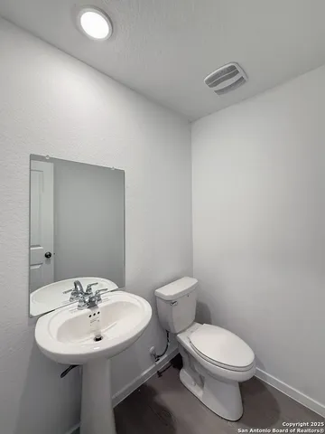 a bathroom with a sink a toilet and mirror