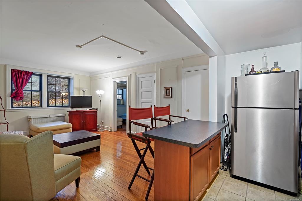 26 Pondfield Road, Unit E Bronxville, NY 10708 - Photo 3 of 10 Kitchen featuring a center island, a kitchen bar, stainless steel refrigerator, and light hardwood / wood-style flooring