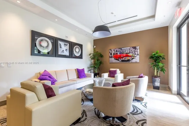 a living room with couches and a potted plant next to a window