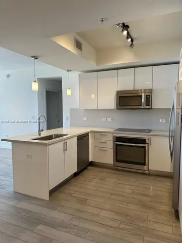 a kitchen with stainless steel appliances kitchen island granite countertop a stove a sink and a microwave