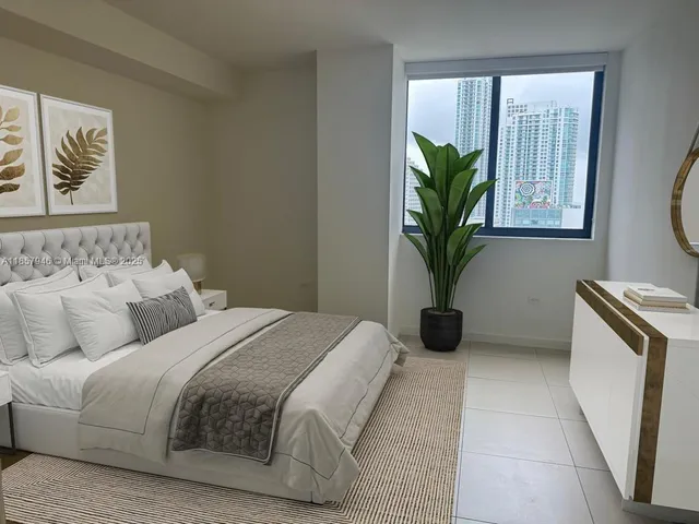 a bedroom with a bed and a potted plant