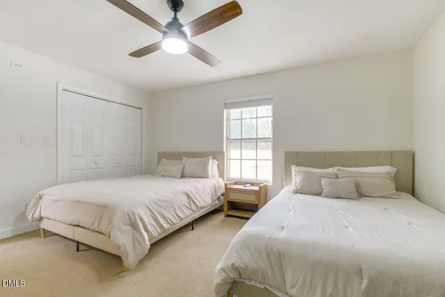 a bedroom with two beds and a window