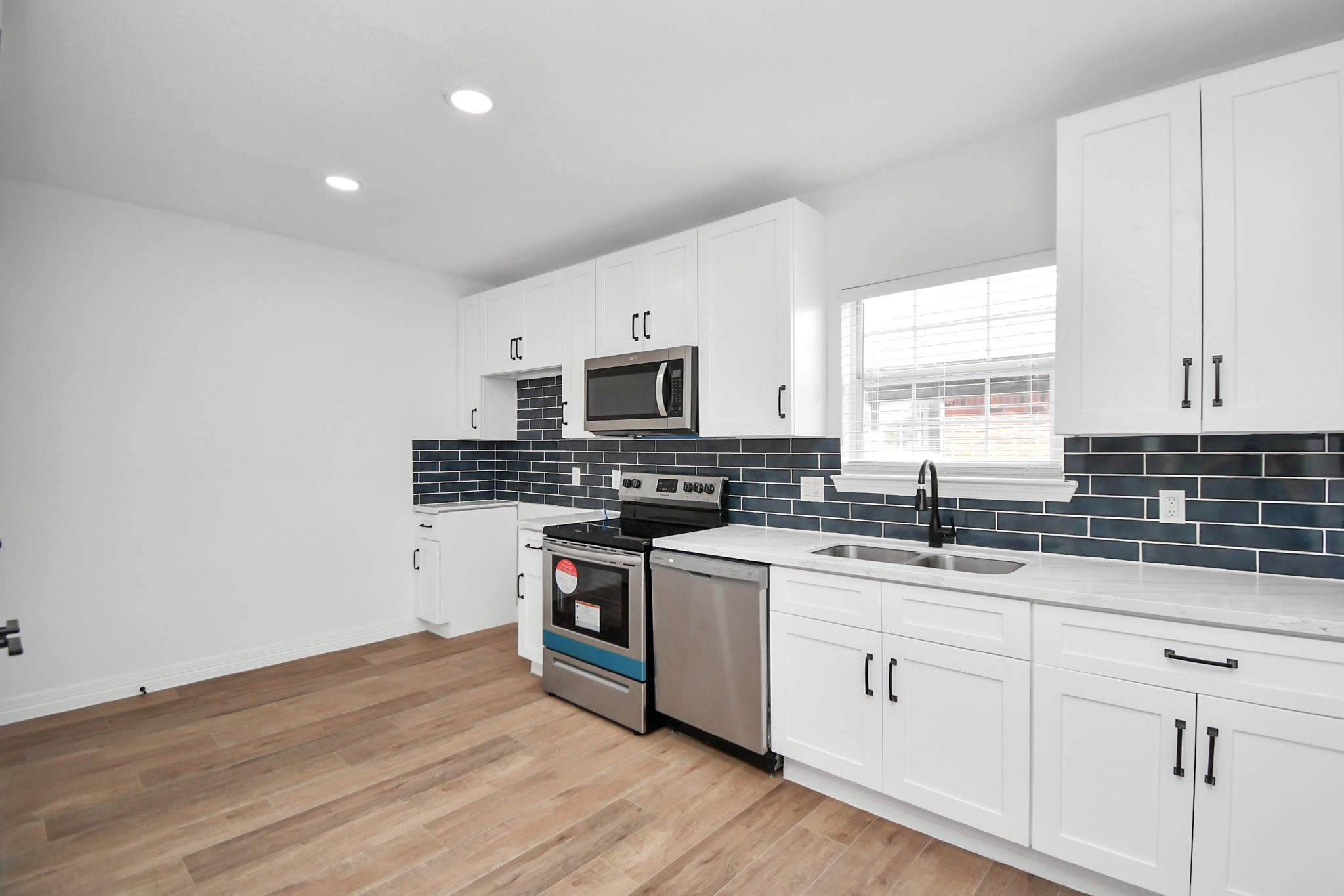 2812 Truxillo Street, Unit B Houston, TX 77004 - Photo 14 of 32 a kitchen with granite countertop white cabinets and white appliances