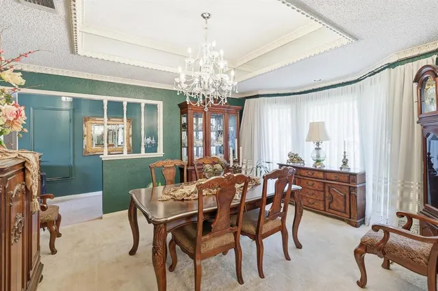 a view of a dining room with furniture and a chandelier