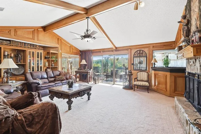 a living room with furniture a fireplace and a large window