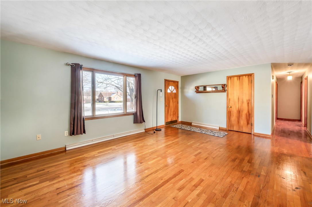 3210 Oser Road Norton, OH 44203 - Photo 15 of 47 Unfurnished living room with a baseboard heating unit and hardwood / wood-style floors