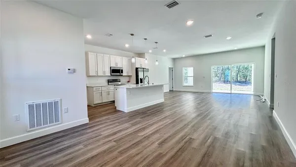 a view of kitchen with sink and refrigerator