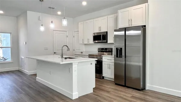 a kitchen with stainless steel appliances a microwave a sink and a refrigerator