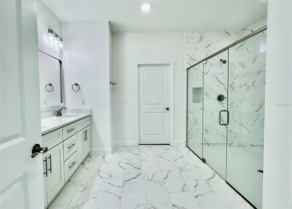 a bathroom with a shower sink and mirror