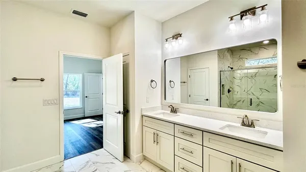 a en suite bathroom with a granite countertop sink mirror and shower