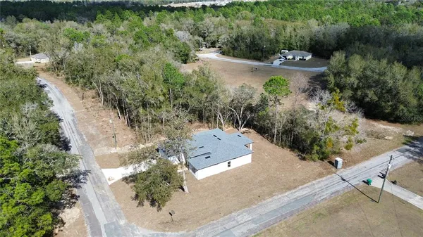 an aerial view of a house with a yard and lake view