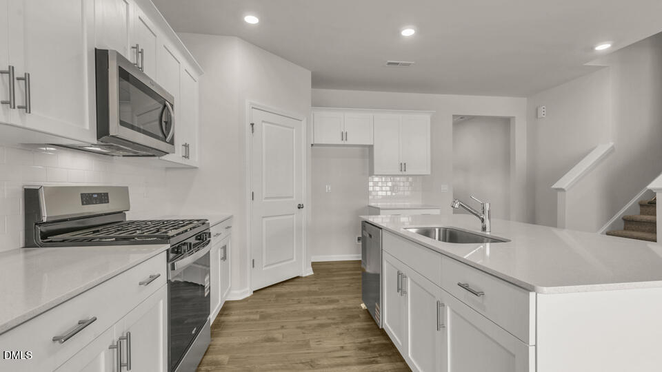 1281 Pavo Path Wendell, NC 27591 - Photo 11 of 54 a kitchen with stainless steel appliances granite countertop a sink stove and refrigerator