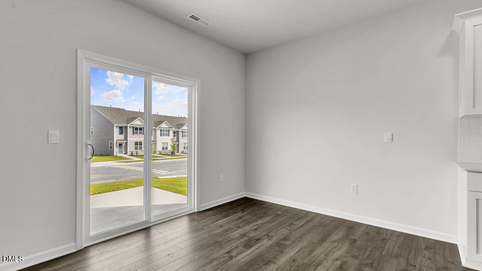 1281 Pavo Path Wendell, NC 27591 - Photo 12 of 54 an empty room with wooden floor and windows