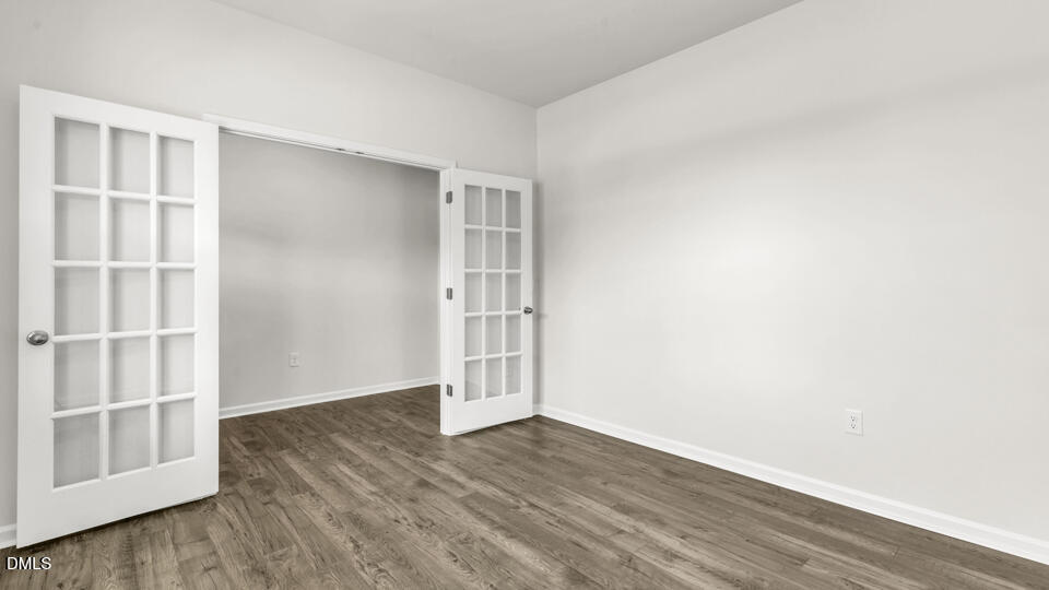 1281 Pavo Path Wendell, NC 27591 - Photo 7 of 54 an empty room with wooden floor and empty shelves