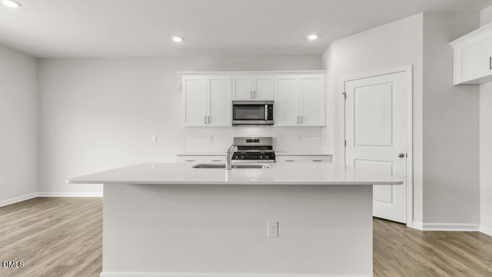 1281 Pavo Path Wendell, NC 27591 - Photo 9 of 54 a kitchen with kitchen island a sink a stove and a refrigerator