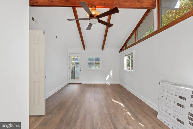 a view of hallway with stairs and wooden floor