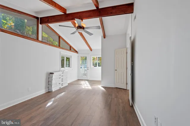 a view of a big room with wooden floor and windows