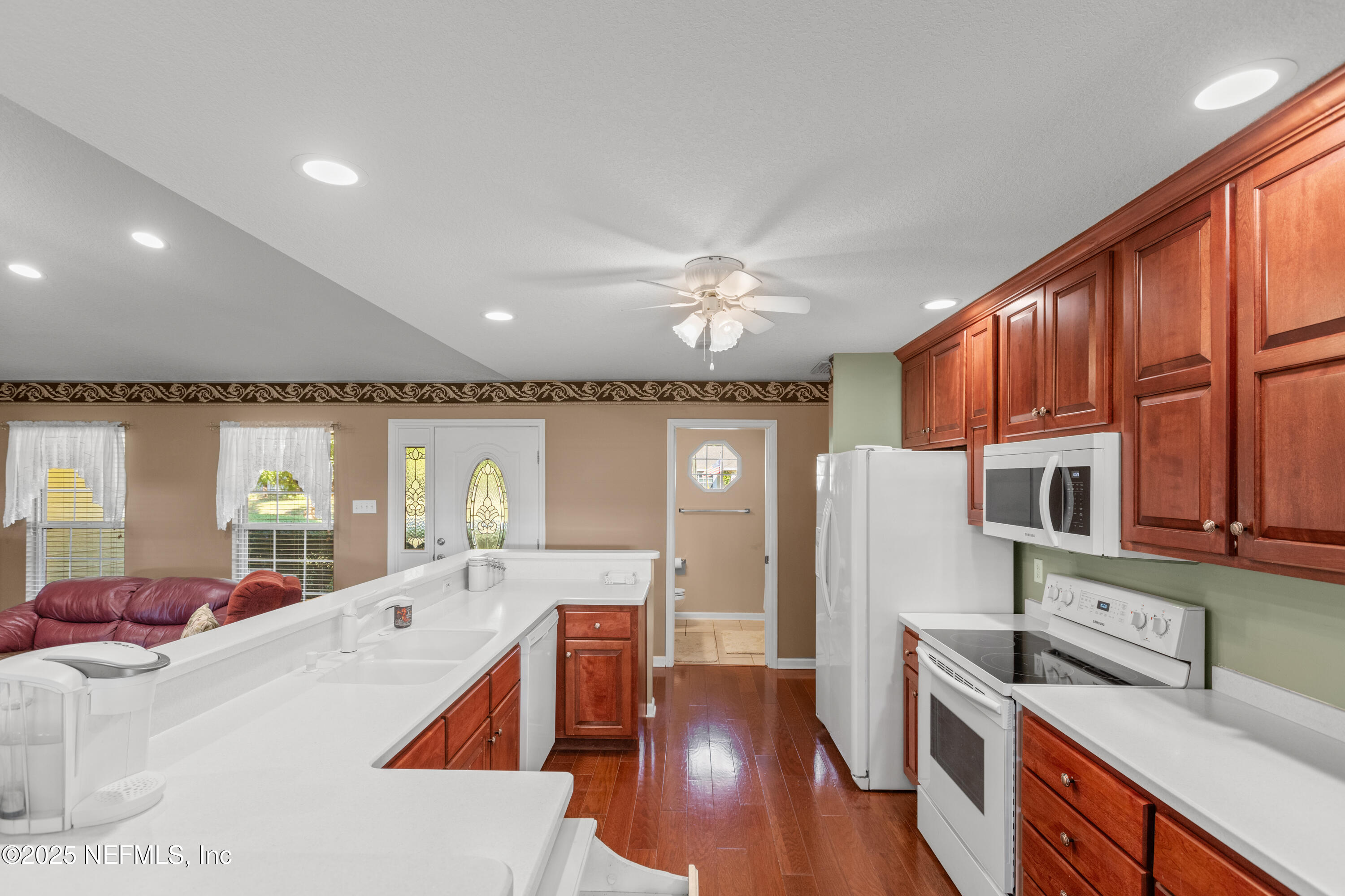 618 Southeast 44th Street Keystone Heights, FL 32656 - Photo 32 of 66 a large kitchen with stainless steel appliances wooden floors and wooden cabinets