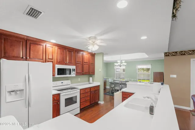 a view of a livingroom with a chandelier fan and a window