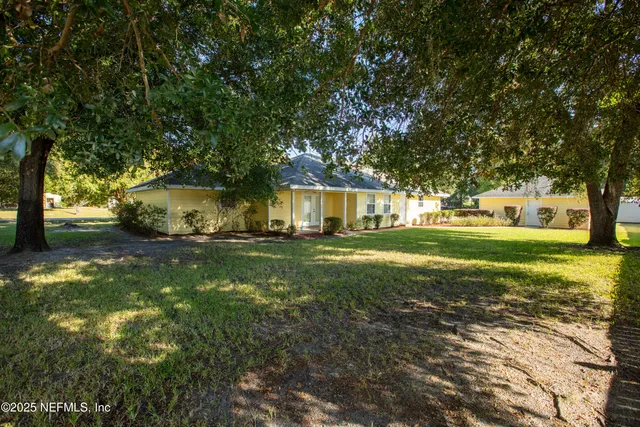 a front view of a house with yard and green space
