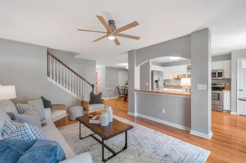 a living room with furniture and a view of kitchen