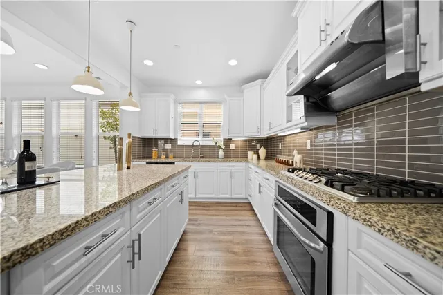 a large kitchen with stainless steel appliances granite countertop lots of counter space a sink and cabinets