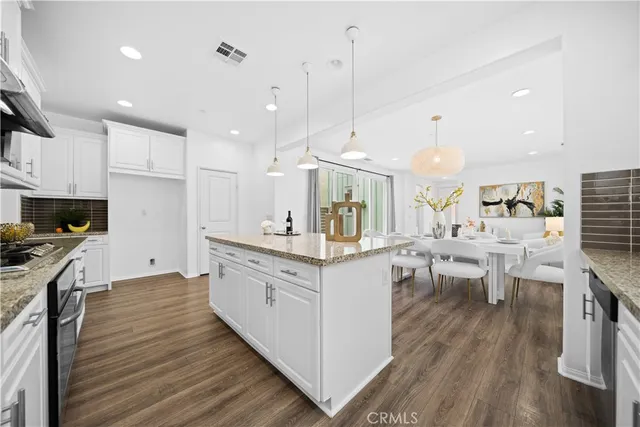 a kitchen with white cabinets and sink