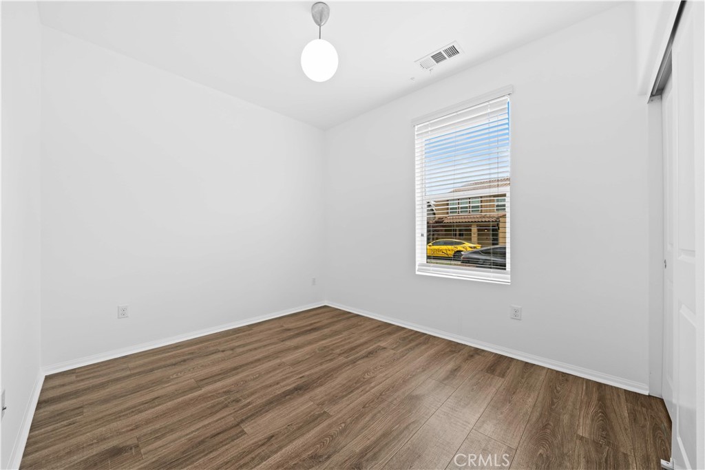 145 Mongoose Irvine, CA 92618 - Photo 16 of 37 a view of an empty room with wooden floor and a window