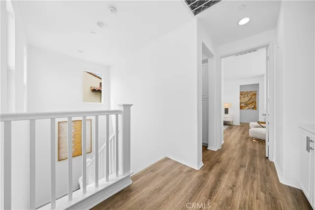 a view of a hallway with wooden floor and a living room